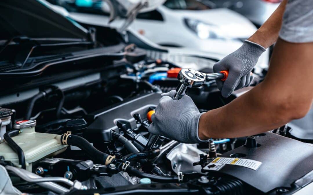 An auto mechanic using a wrench as part of engine services